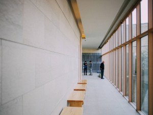 A curved walkway with a full height wood framed partition wall on the right hand side